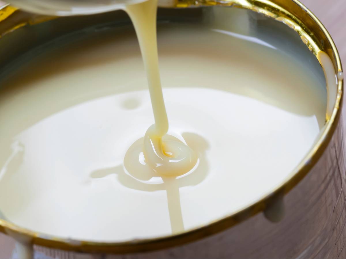Garnek z mlekiem zagęszczonym. Obrazek w artykule Jak odróżnić mleko skondensowane od zagęszczonego? Praktyczny przewodnik po produktach z mleka